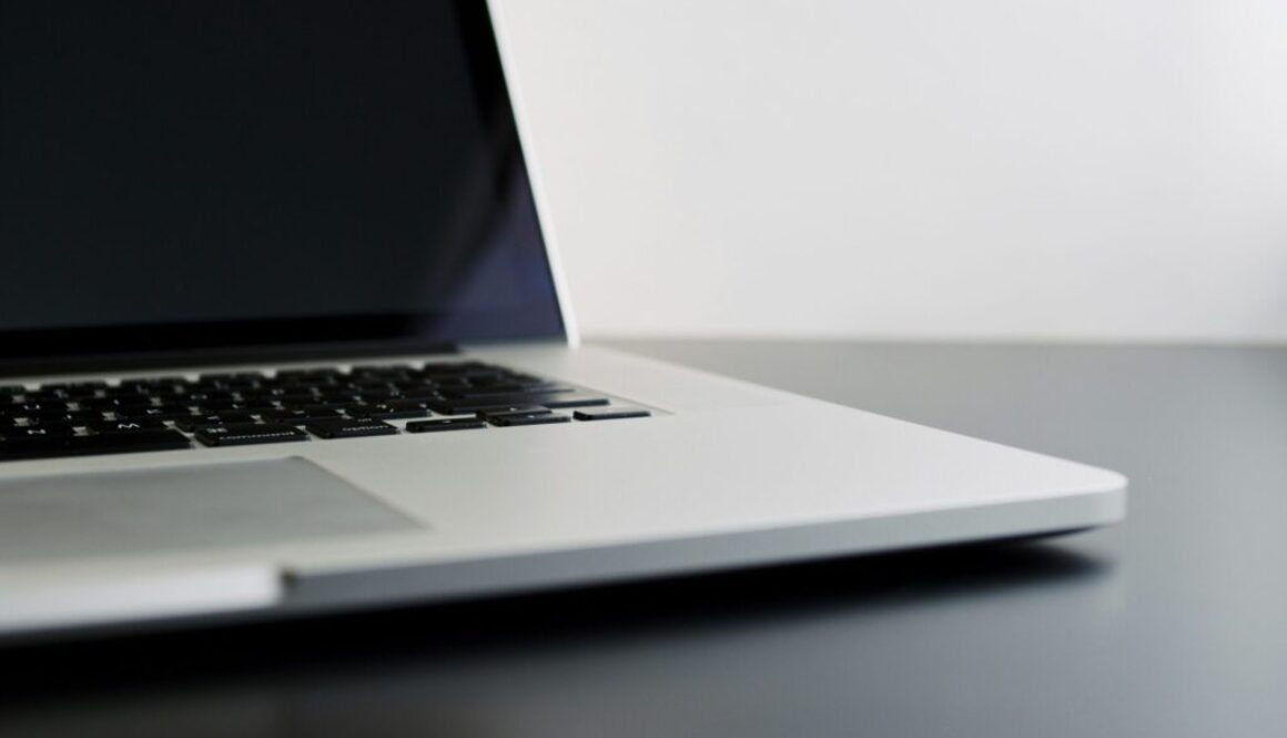 silver laptop computer on black table